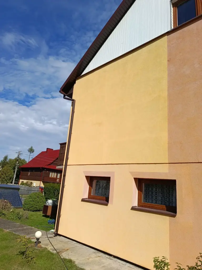 Żółta elewacja domu po myciu - czysty tynk bez zacieków